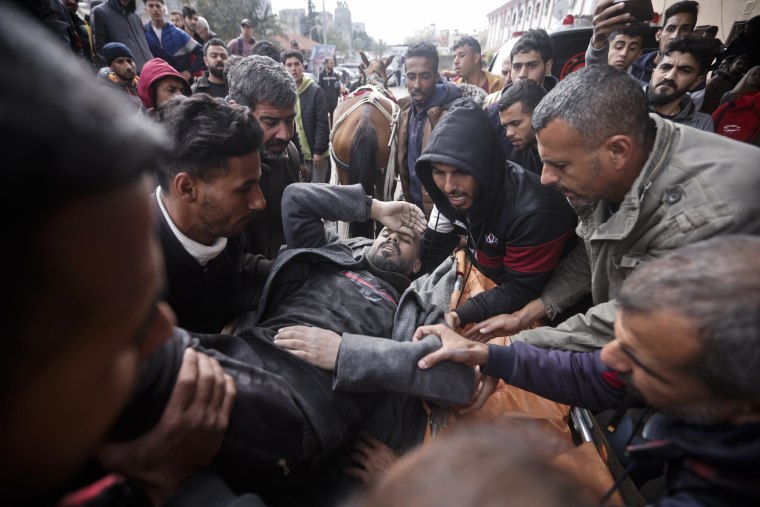 فلسطينيون يقومون بإجلاء رجل جريح بعد غارة إسرائيلية في خان يونس بقطاع غزة، الجمعة، 12 يناير، 2024.