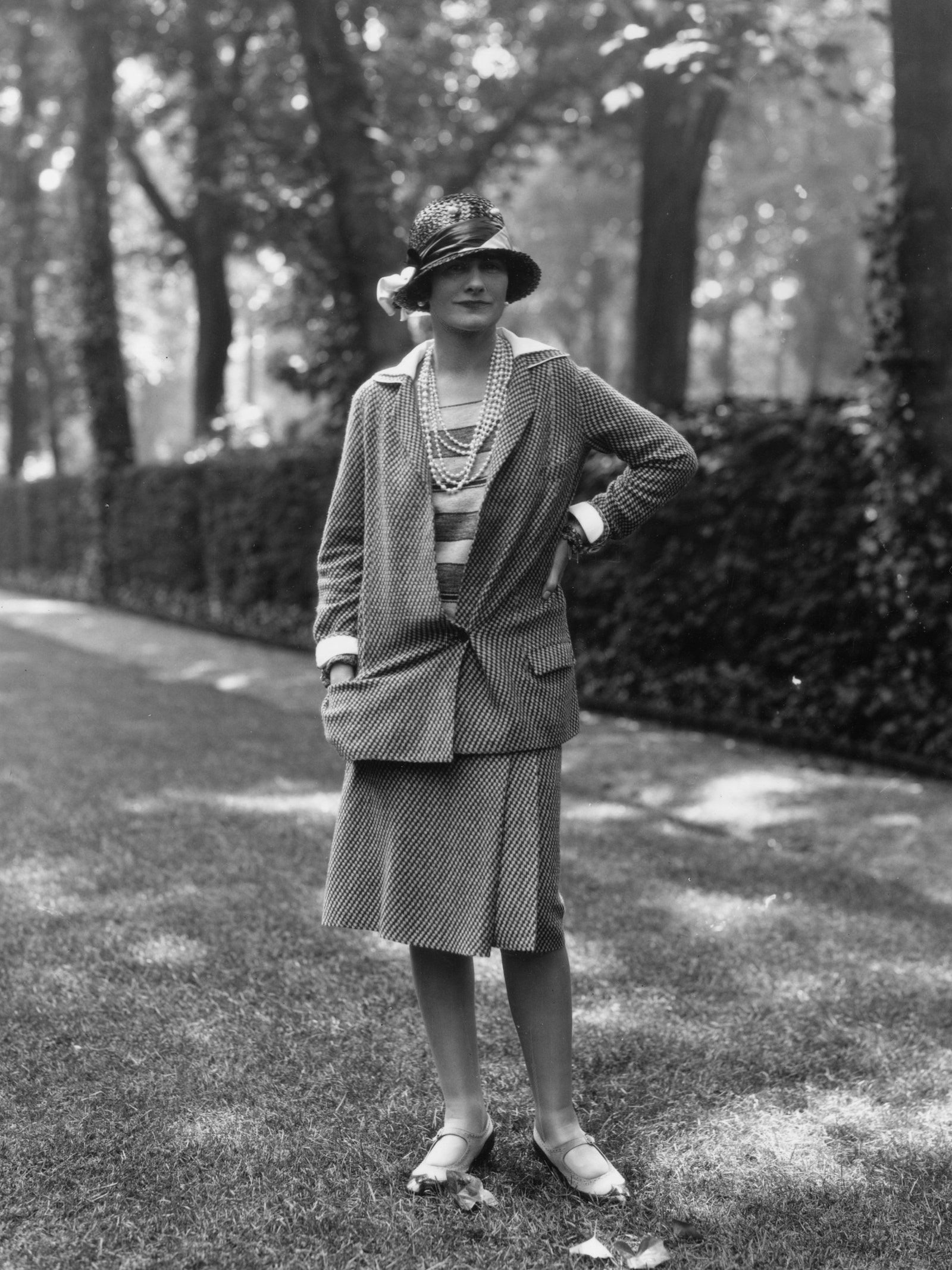 ربما تحتوي الصورة على Coco Chanel، ملابس الشخص، المعطف، الوجه، الرأس، التصوير الفوتوغرافي، الصورة الدائمة، الأحذية والأحذية