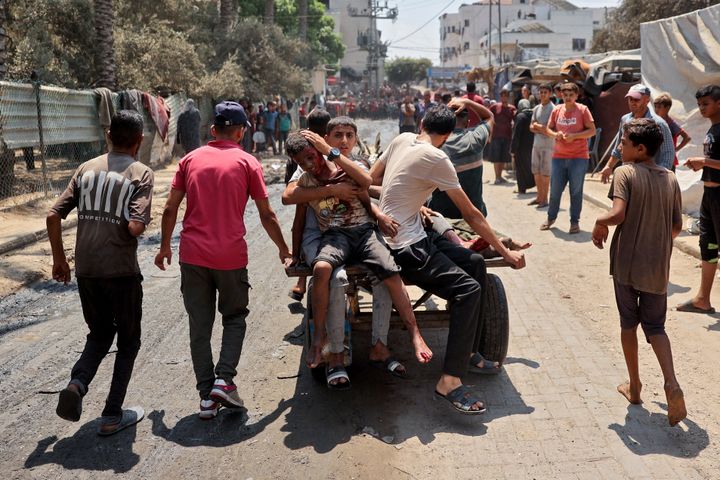 فلسطينيون أصيبوا خلال غارة إسرائيلية على مدرسة خديجة التي تؤوي نازحين، يركبون على ظهر عربة في دير البلح، وسط قطاع غزة في 27 يوليو 2024، وسط الصراع المستمر بين إسرائيل وجماعة حماس المسلحة. (تصوير: إياد بابا/وكالة الصحافة الفرنسية عبر صور جيتي)