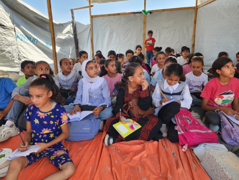 KHAN YUNIS, GAZA - SEPTEMBER 03: Students take part in lessons at their tent school, in which their teacher Alaa Abu Mustafa, whose house was destroyed in the Israeli army's attacks, gives them education in Khan Yunis, Gaza on September 03, 2024. The tent school was built on the rubble of the destroyed house of the teacher. Despite the limited and difficult conditions, teacher Alaa strives to ensure that primary school students are not deprived of education. (Photo by Hani Alshaer/Anadolu via Getty Images)