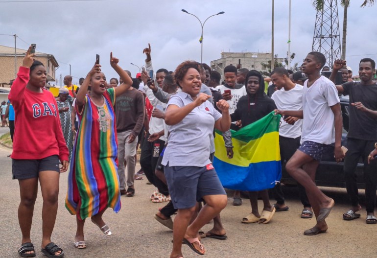 epa10828152 People display the Gabon national flag as they celebrate in the streets of Akanda, Gabon, 30 August 2023. Members of the Gabonese army on 30 August announced on national television that they were canceling the election results and putting an end to Gabonese President Ali Bongo's regime, who had been declared the winner. EPA-EFE/STRINGER