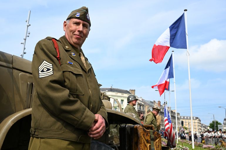 A reenactor dressed in a US paratrooper WWII uniform takes part in the Commemoration of the 80th anniversary of the end of World War II in Europe, in Reims, north eastern France, where Nazi Germany signed its initial 1945 surrender, on May 7, 2025.
