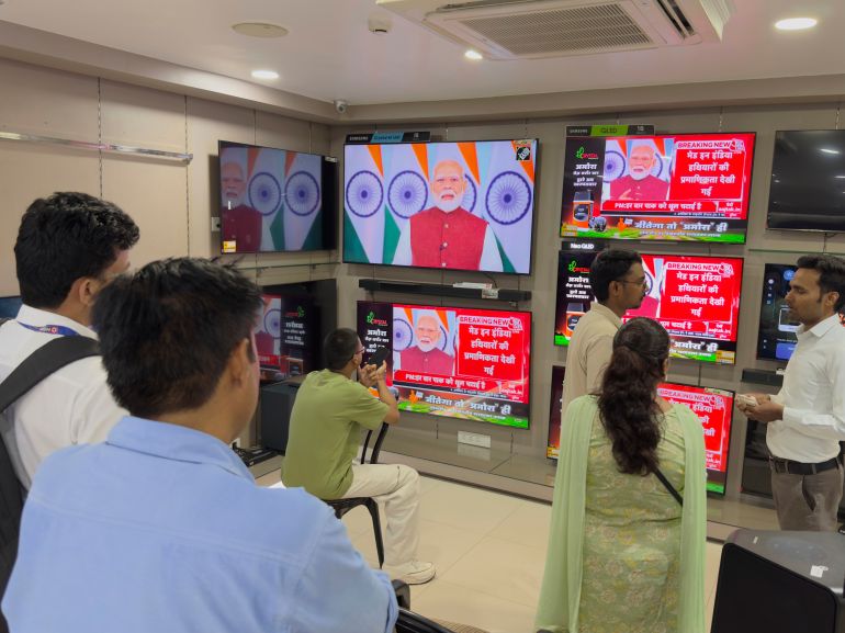 Indians watch the live telecast of Indian Prime Minister Narendra Modi's speech on television screens, in Prayagraj, in the northern Indian state of Uttar Pradesh, India, Monday, May 12, 2025. (AP Photo/Rajesh Kumar Singh)