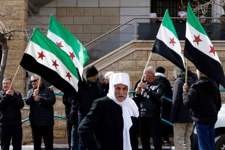 Druze residents of the village of Majdal Shams in the Israeli-annexed Golan Heights wave Syrian flags as they take part in a rally on February 14, 2025, to protest against the 1981 annexation law of the strategic plateau which Israel captured from Syria during the 1967 Arab-Israeli war. (Photo by Jalaa MAREY / AFP)